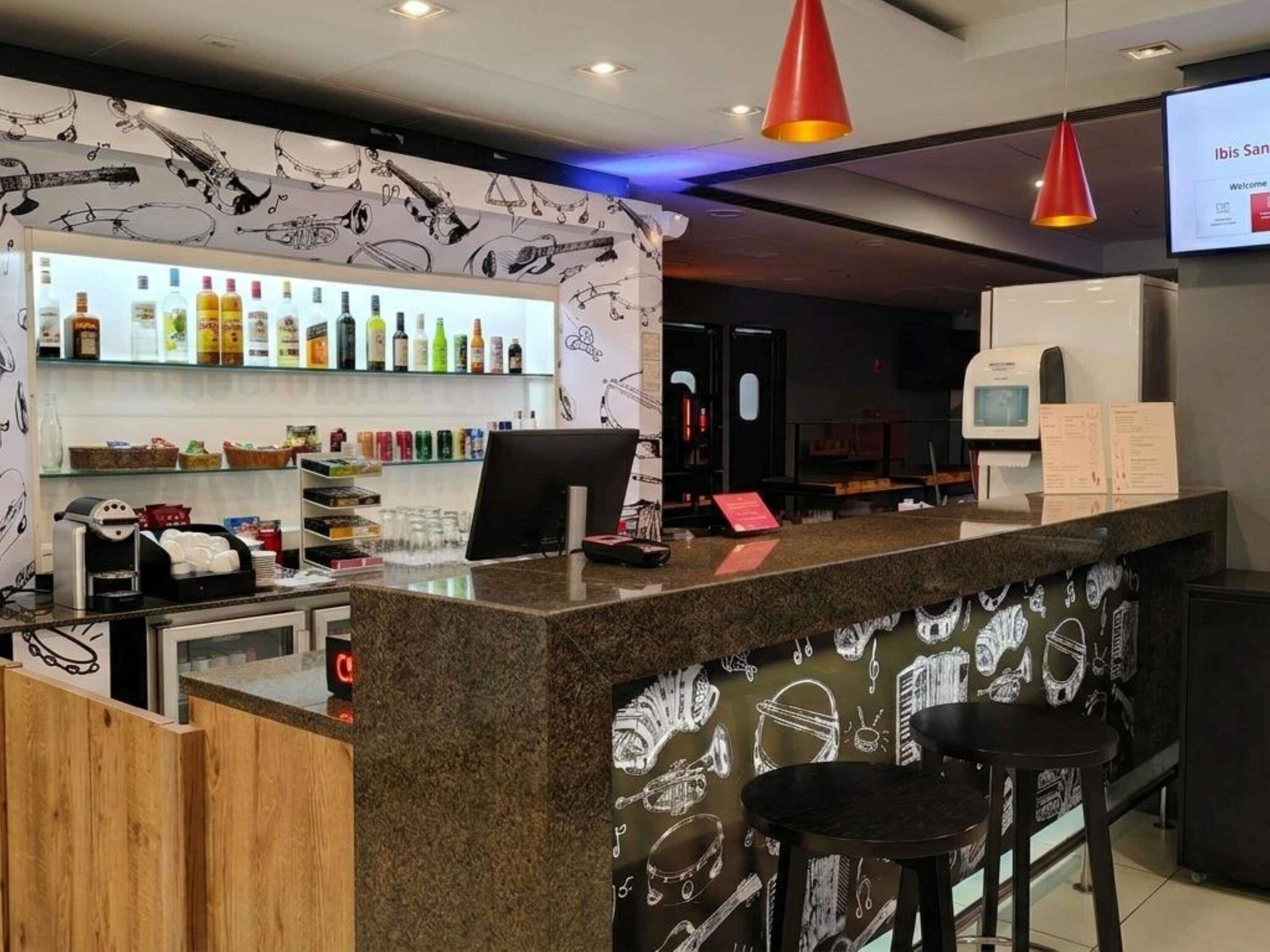 A bar area with a counter, a coffee machine, and a menu board.