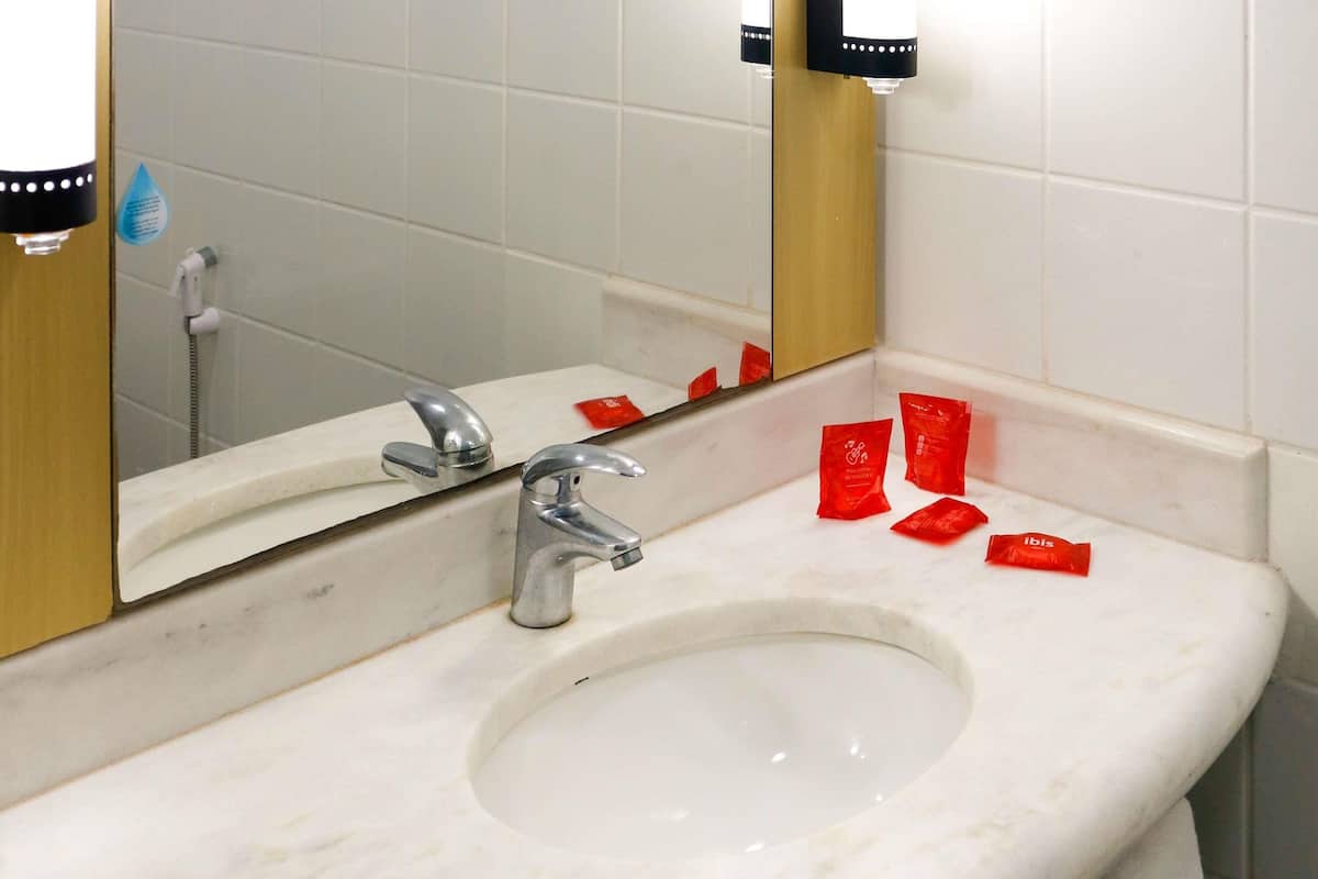 A bathroom with a sink, mirror, and a towel rack.
