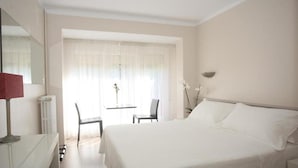 A hotel room with a bed, a desk, a chair, a table, and a window with curtains. - Sol Park (Sant Julia de Loria)