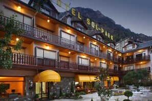 A multi-story hotel with balconies, a sign reading "Hotel Sol Park," and a stone facade. - Sol Park (Sant Julia de Loria)