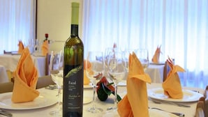 A dining table set with plates, glasses, and a bottle of wine. - Sol Park (Sant Julia de Loria)