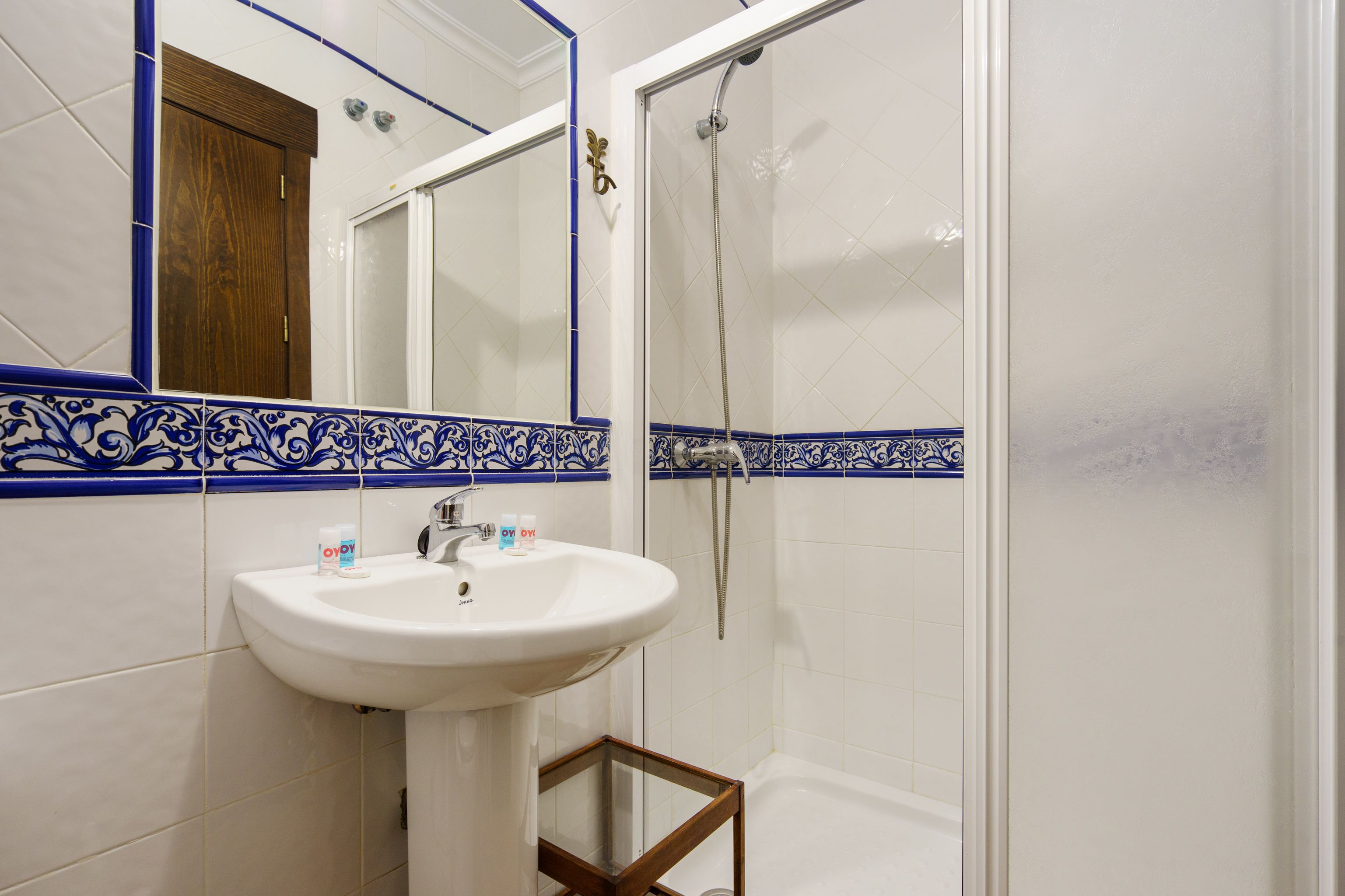 A bathroom with a white sink, mirror, and shower.