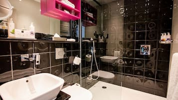 A modern bathroom with a large mirror, a white sink, a bathtub, and a glass-enclosed shower.