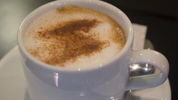 Una taza de café con un poco de canela por encima.