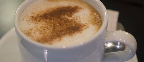 A cup of coffee with a sprinkle of cinnamon on top.