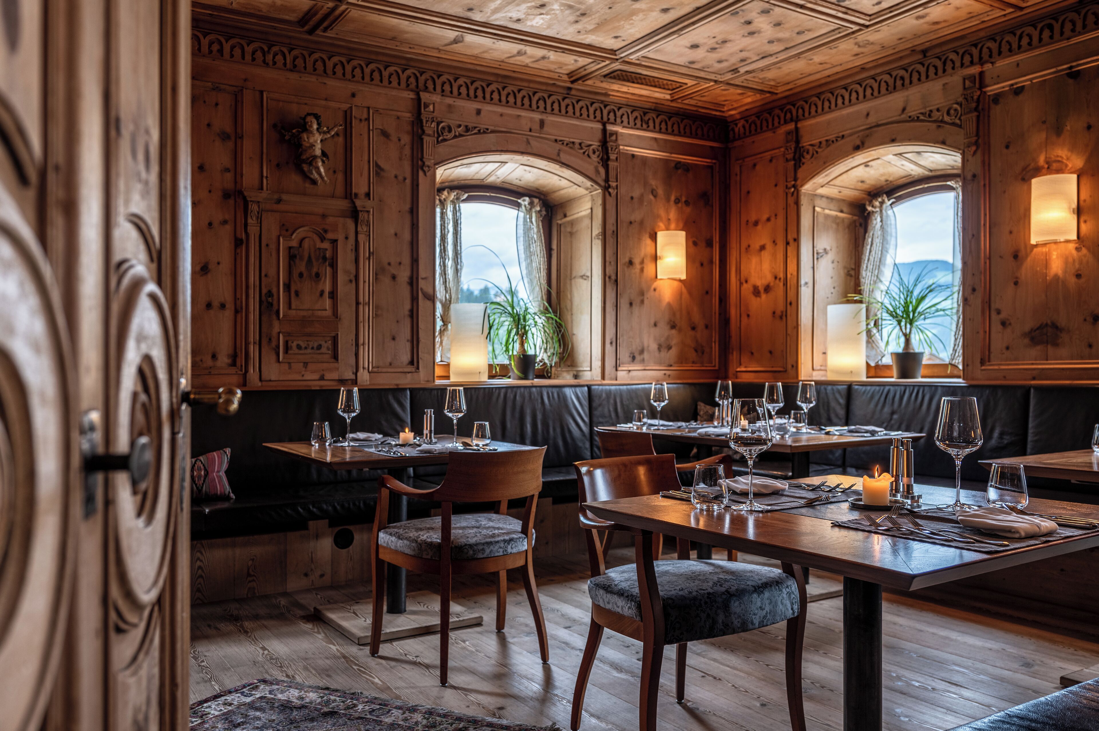Un restaurante con paneles de madera, asientos de cuero y mesas dispuestas para comer.