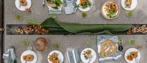 A top-down view of a dining table set with various dishes, including salads, bread, and a drink.
