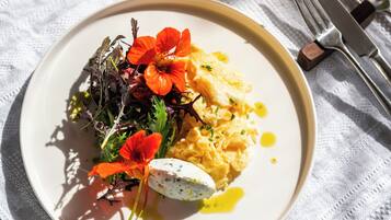 A plate of food with a salad, eggs, and flowers on a white plate.