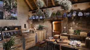 Una cocina rústica con mostradores de madera, plantas colgantes y una variedad de alimentos exhibidos.