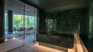 Relax in a serene spa area with a bench and shower, offering a view of outdoor seating.