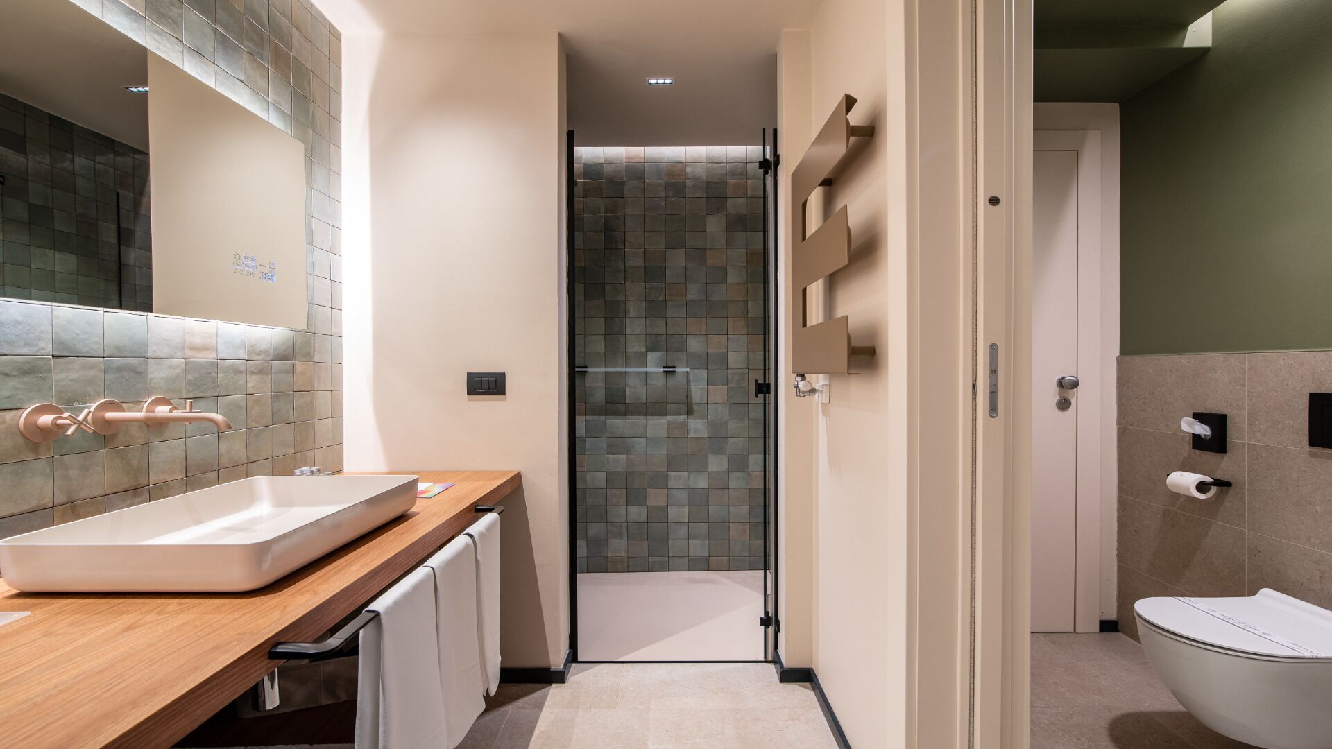 Un bagno moderno con un lavandino grande, uno spazio doccia e un water.