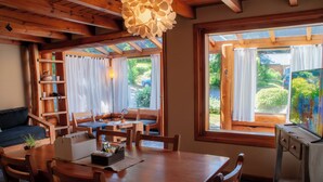 Un coin repas accueillant, avec des meubles en bois, une table dotée d’un coffre intégré et un tableau accroché au mur.