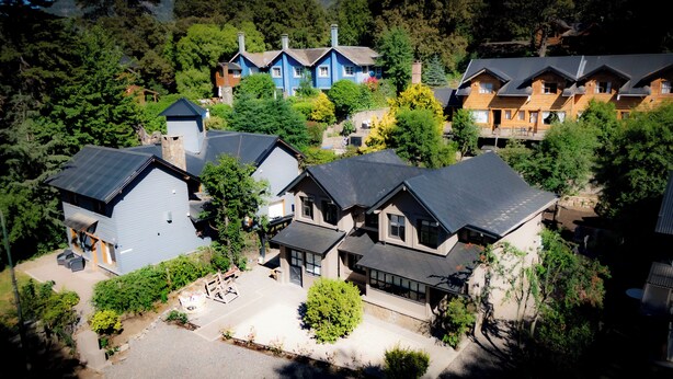 Un quartier résidentiel composé de plusieurs maisons, dont une maison bleue avec une cheminée et une maison grise dotée d’une grande fenêtre.
