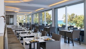 Un restaurant moderne doté d’un long comptoir et de grandes fenêtres donnant sur une plage.