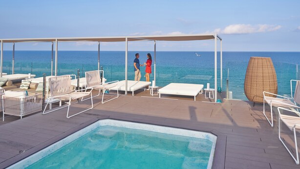 Un espace aménagé au bord de la piscine, avec des chaises longues et une piscine.