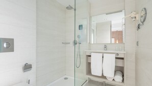 Une salle de bain moderne avec une douche à parois de verre, un meuble-lavabo avec un miroir et des toilettes.