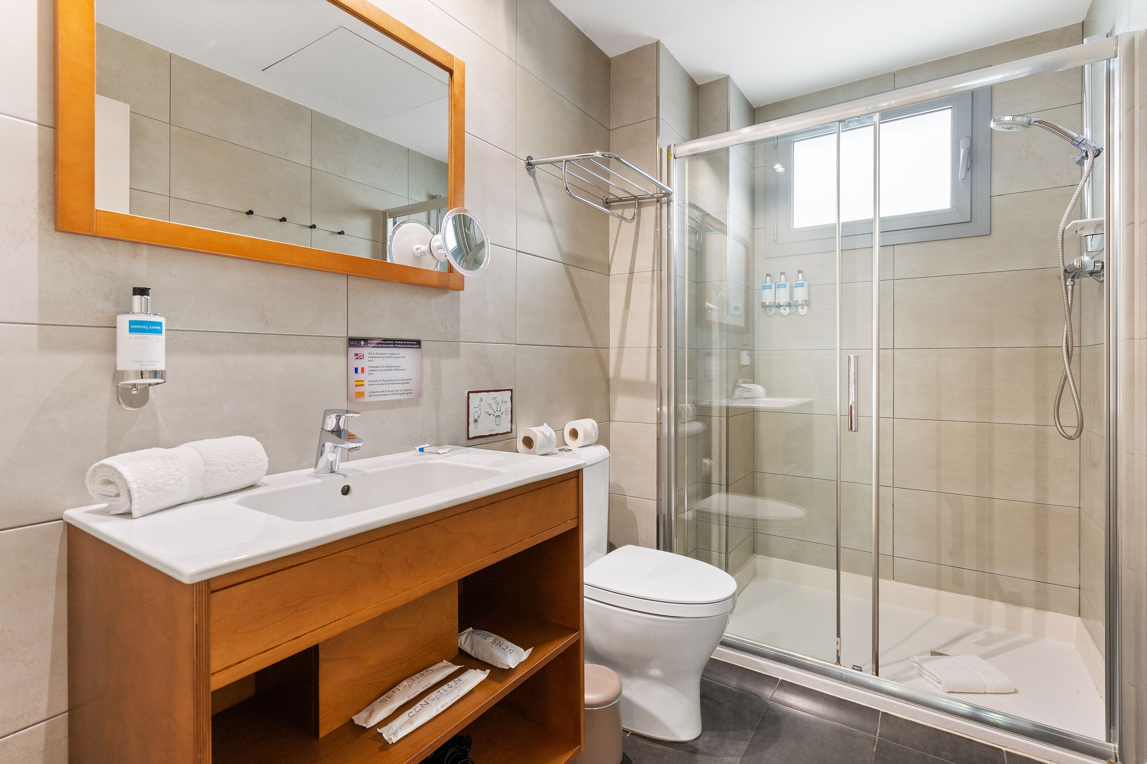 A modern bathroom with a sink, mirror, and toilet.