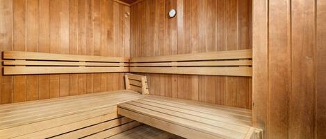 Un sauna en bois avec des bancs et une horloge au mur.