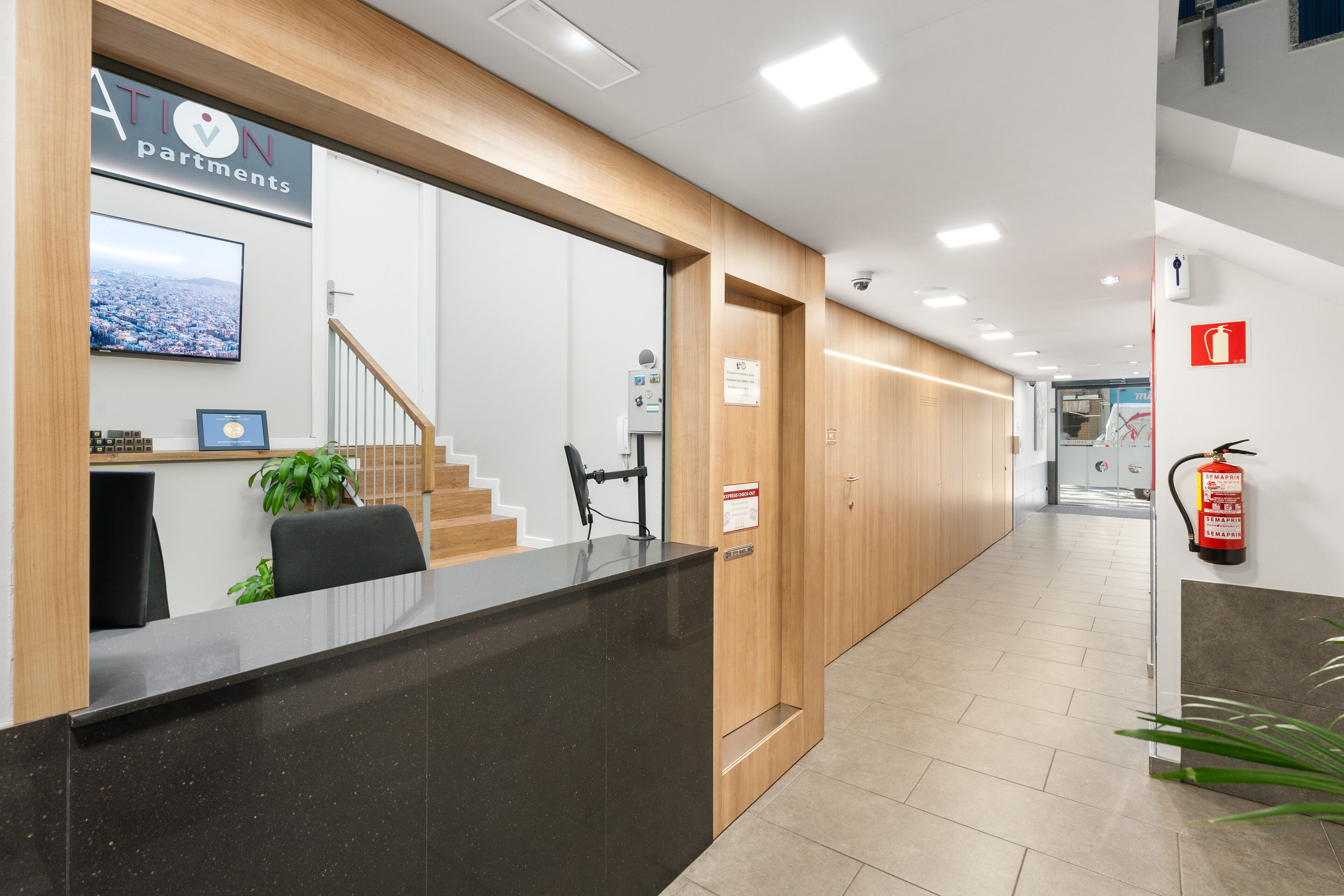 A reception area with a reception desk, a staircase, and a fire extinguisher.