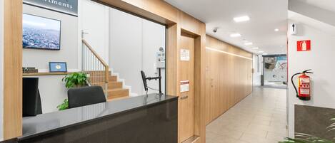 A reception area with a reception desk, a staircase, and a fire extinguisher.