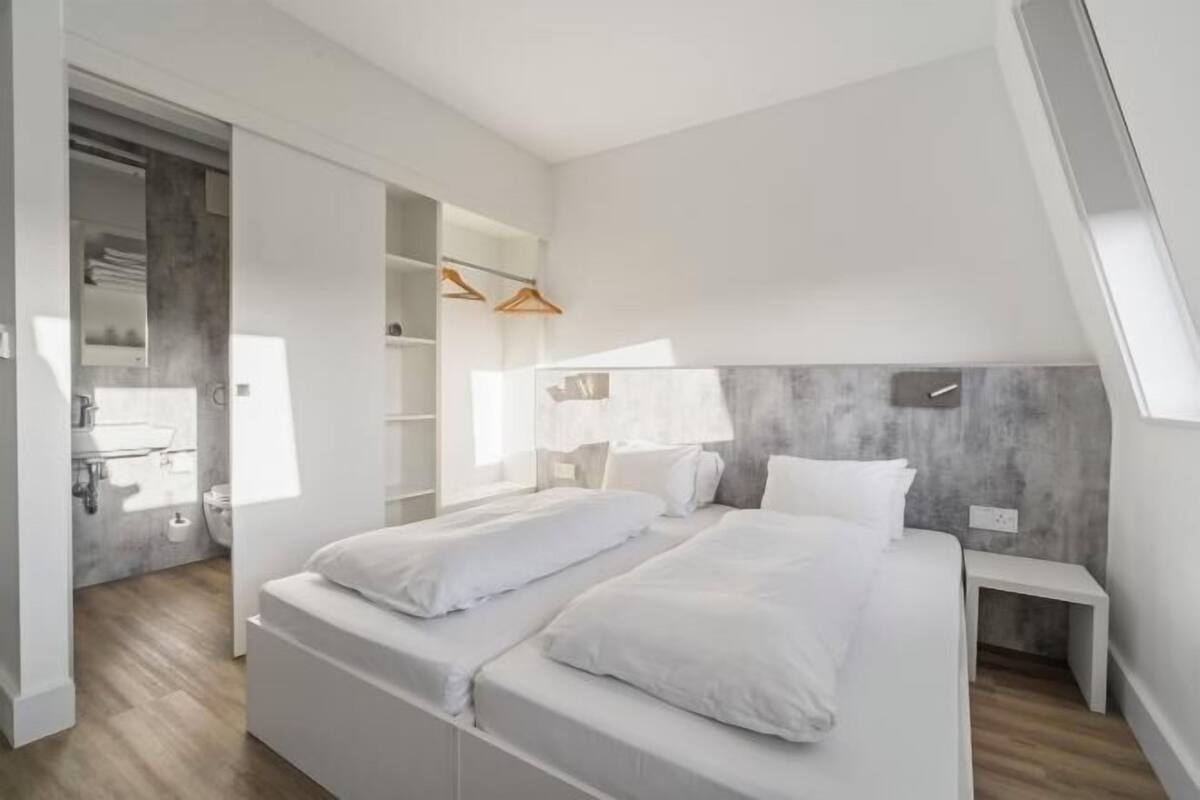 Et moderne soveværelse med hems, indbyggede reoler og walk-in closet.