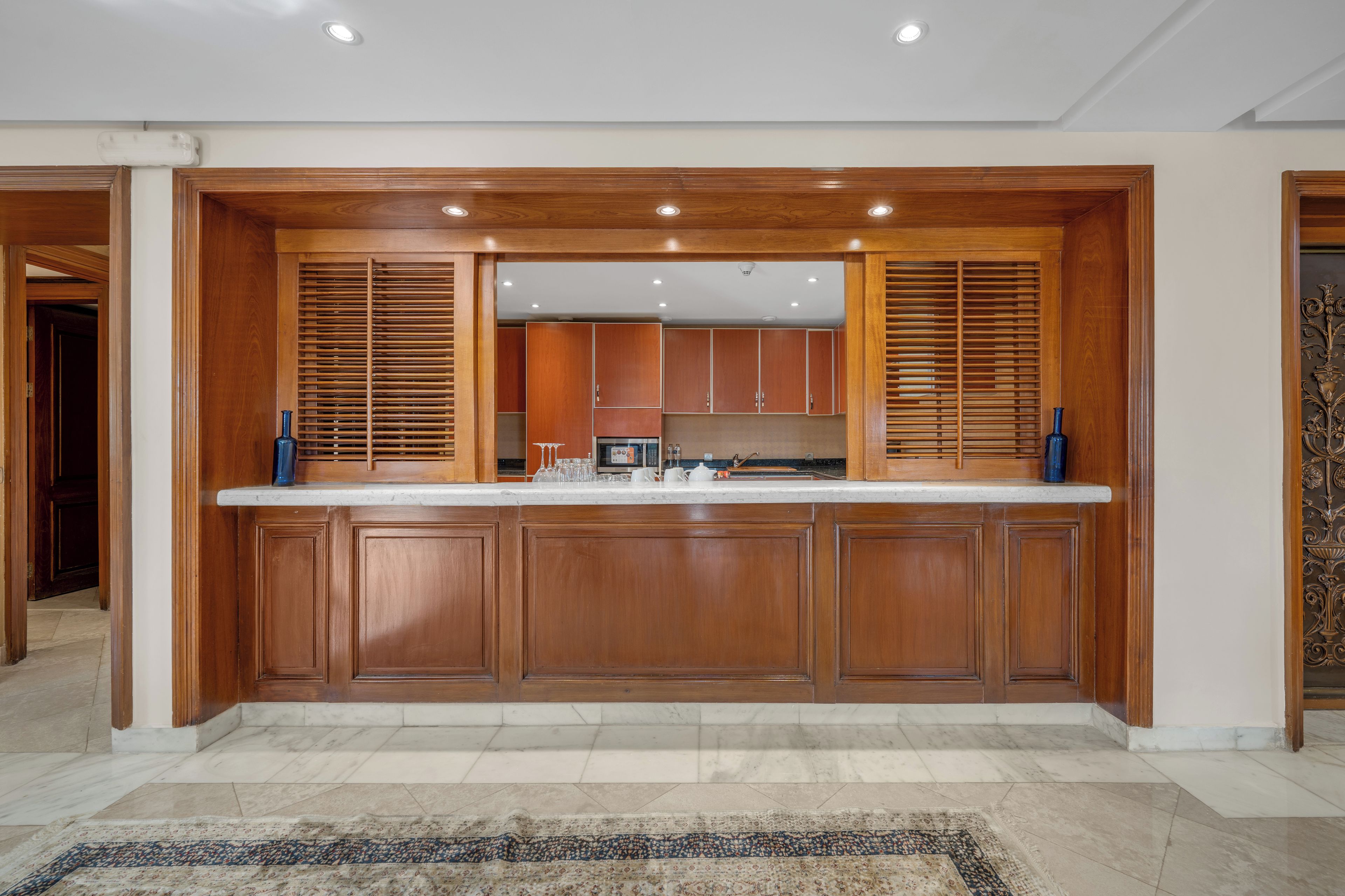 Una cocina moderna con armarios de madera, encimera de mármol y electrodomésticos integrados.