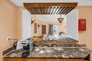 A kitchen with a marble countertop, coffee maker, and various kitchen items. - Royal Savoy Sharm El Sheikh (Sharm El Sheikh)