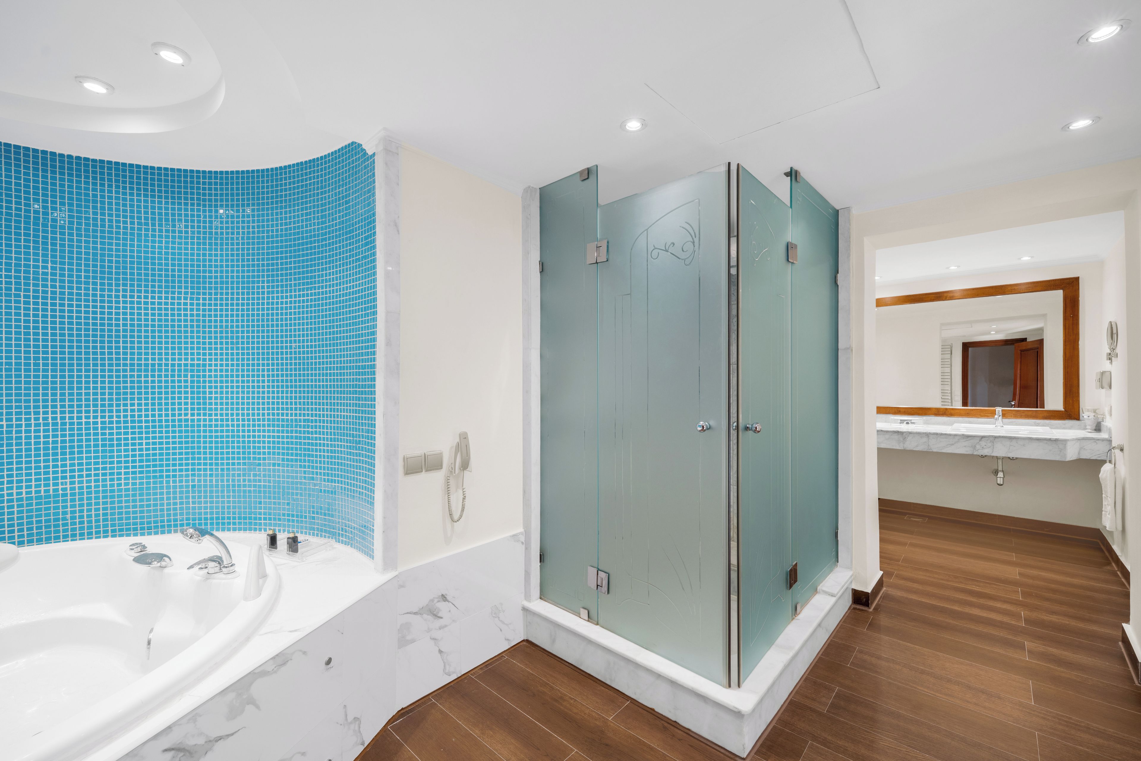 Un baño moderno con bañera, cabina de ducha de vidrio y tocador con espejo.