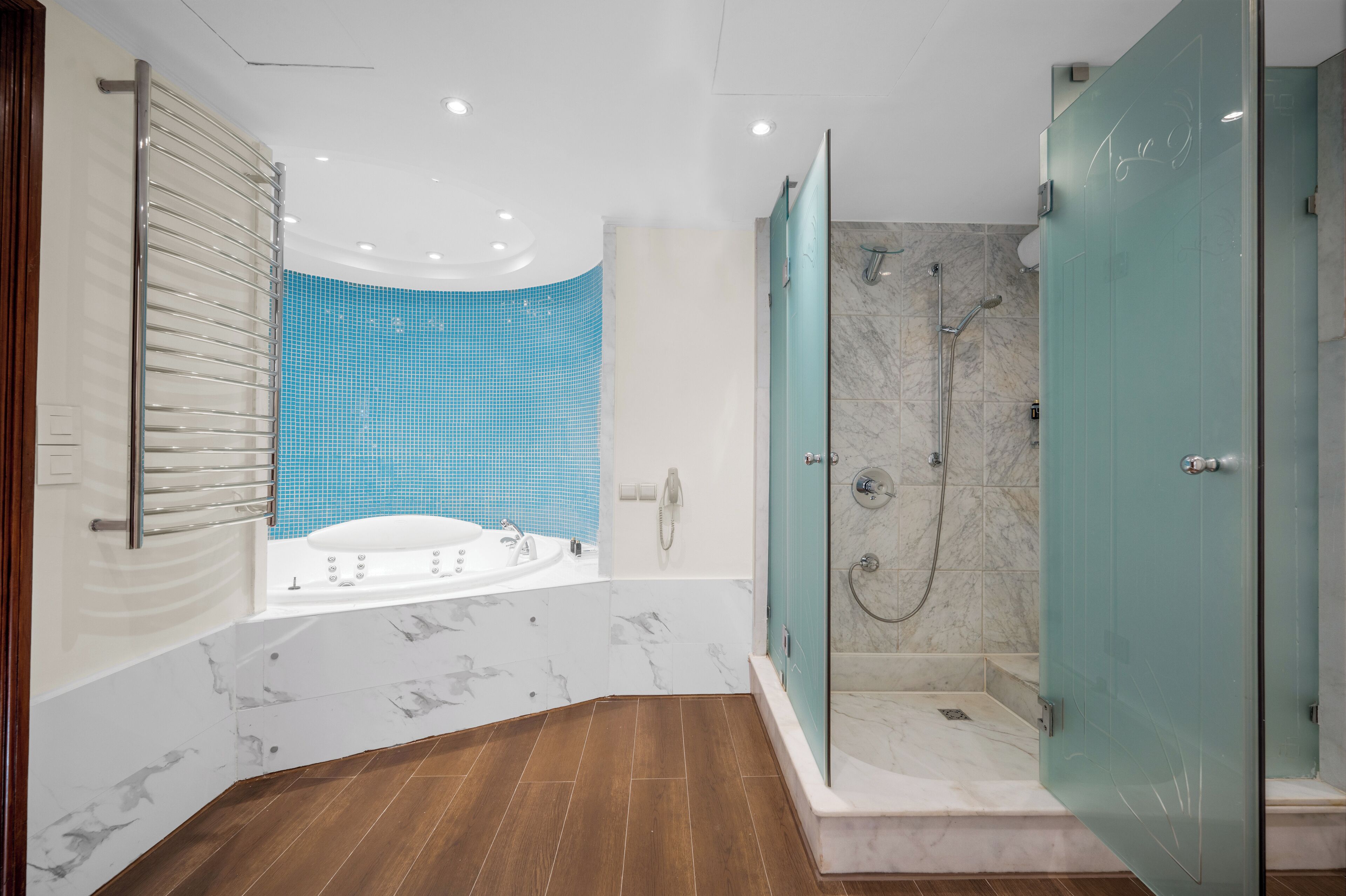 A modern bathroom with a bathtub, shower, and glass-enclosed shower stall.