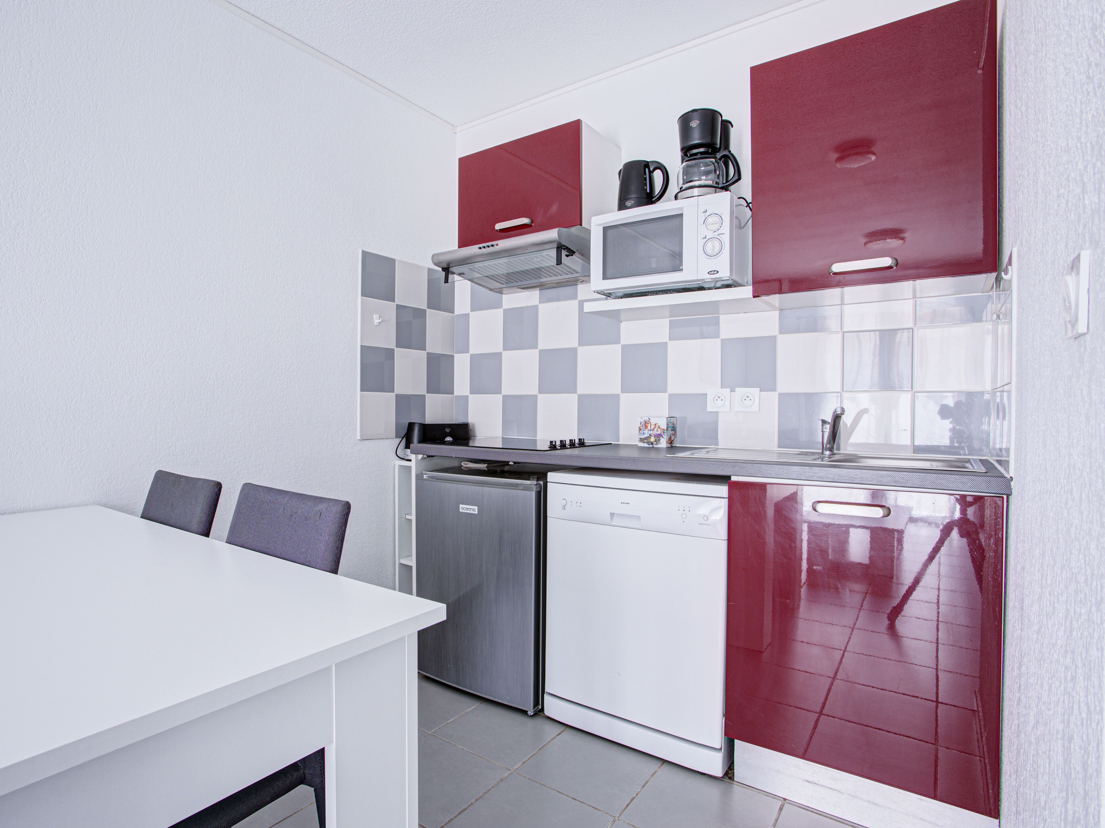 A compact kitchen with a microwave, coffee maker, and dishwasher.