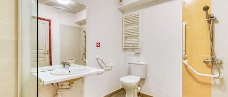 A bathroom with a toilet, sink, shower, and a glass-enclosed shower area.