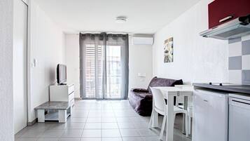 Una cocina moderna con comedor, sofá y televisor.