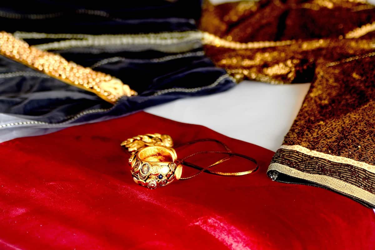 Un lit bien fait, avec un oreiller rouge, un oreiller blanc et une couverture rouge.