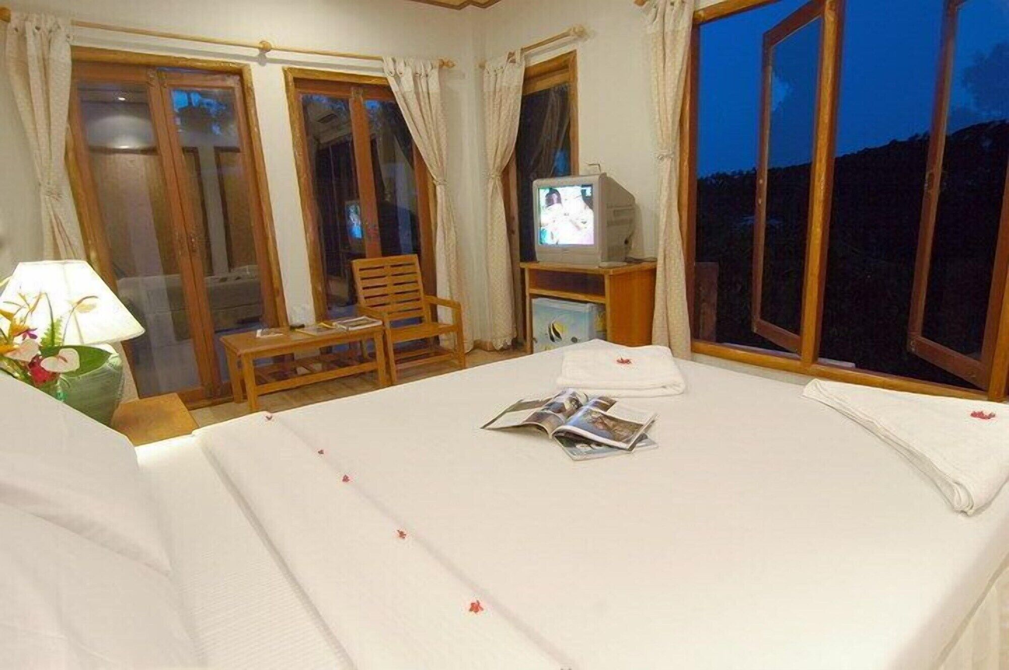 Ein Hotelzimmer mit Bett, Fernseher, Stuhl und Tisch.
