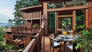 Ein modernes Holzhaus mit einer Terrasse und einer Sitzgruppe im Freien.