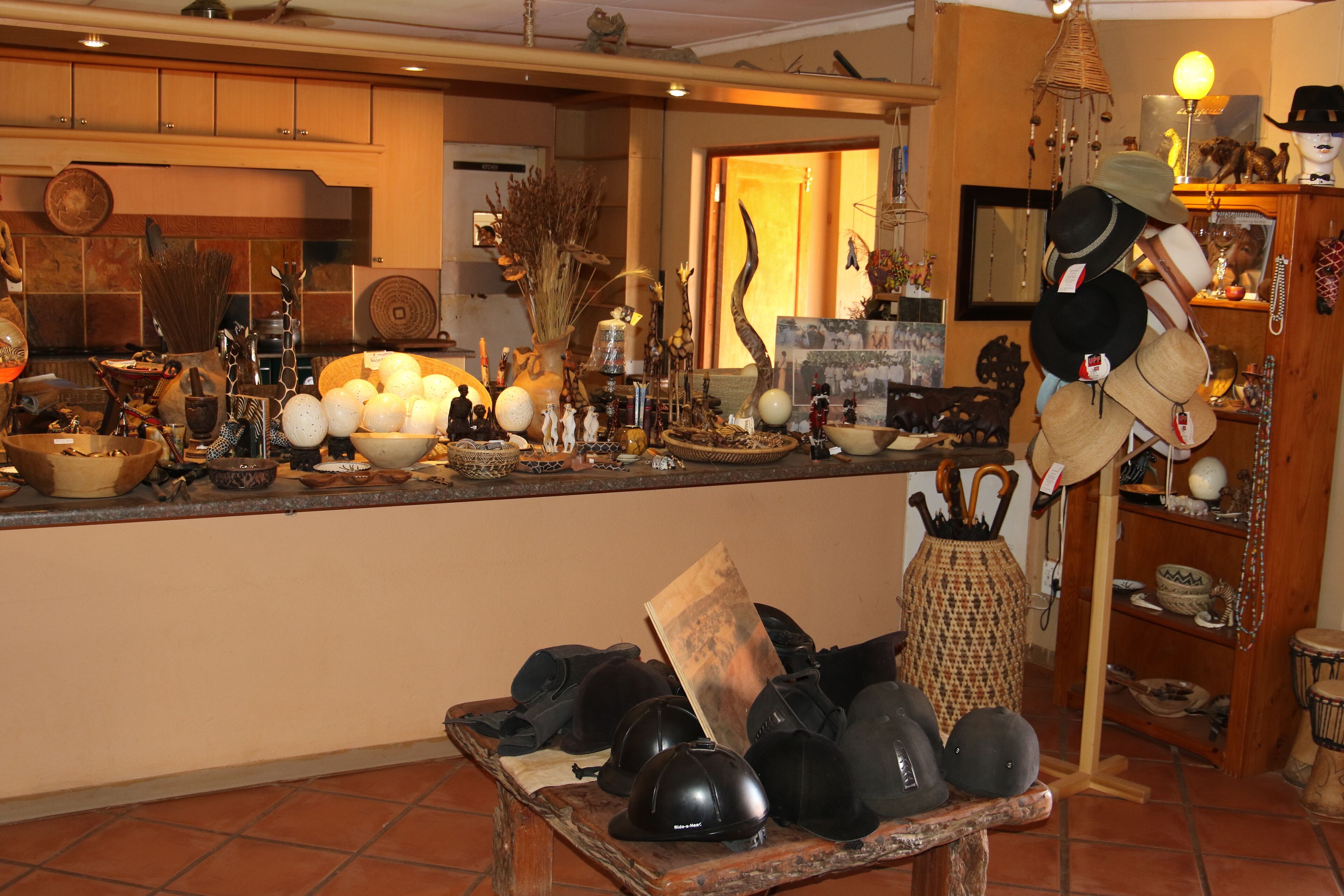 A kitchen with various items on the counter, including hats, a vase, and a wooden table with hats.