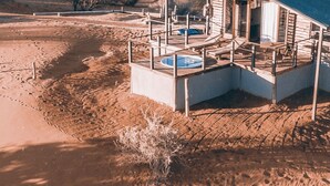 A wooden cabin with a blue roof, a pool, and a deck area. - Bagatelle Kalahari Game Ranch (Mariental)