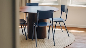 Un espace repas comprenant une table ronde, des chaises et un luminaire suspendu.