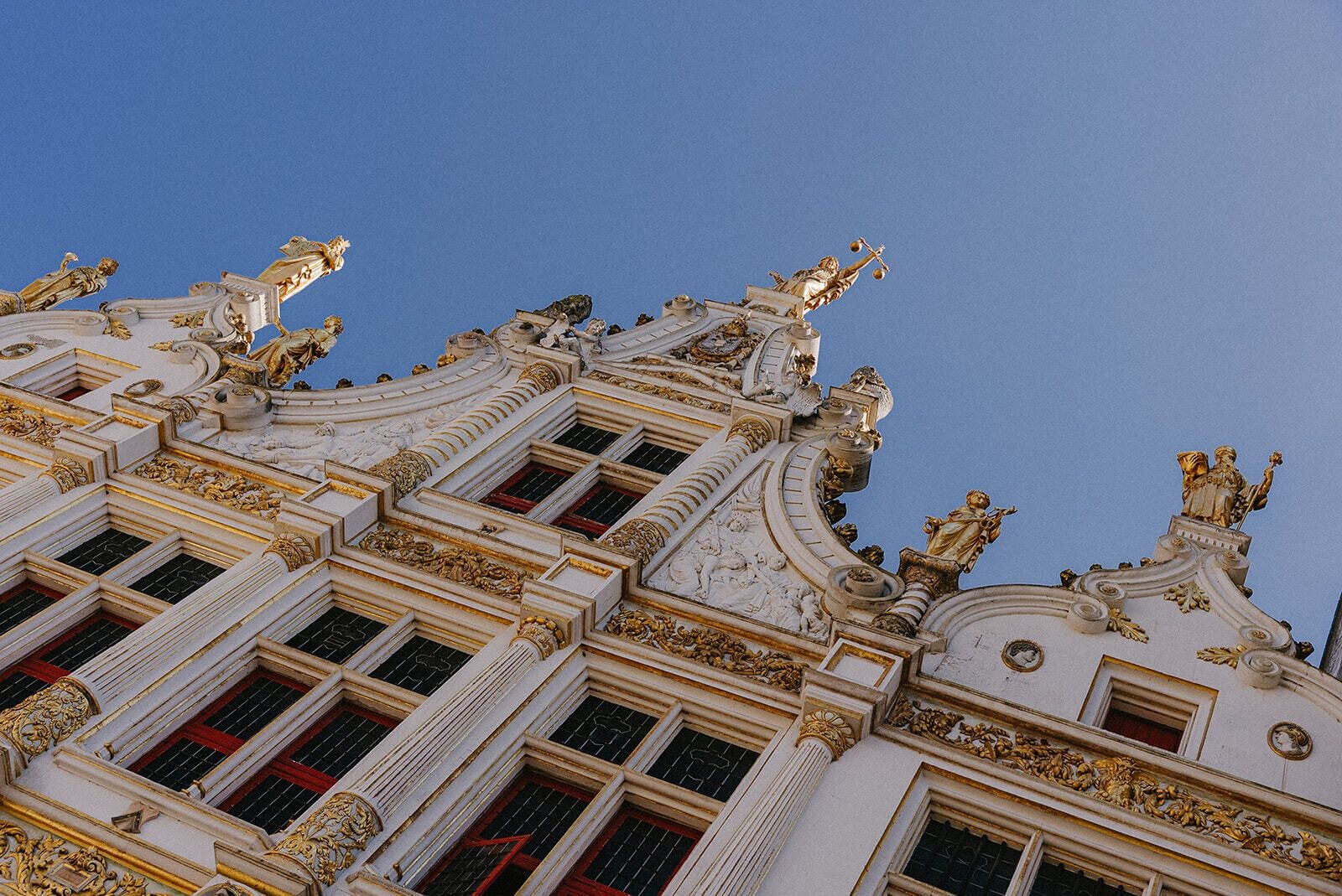 Een gebouw met versierde architectuur, waaronder beelden en decoratieve ornamenten.