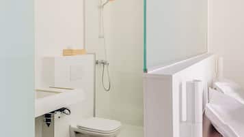 Une salle de bain moderne avec une douche à parois de verre, des toilettes et un lavabo.