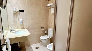 A bathroom with a sink, toilet, and shower.