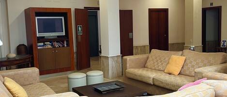 Amplia sala de estar con sofás, televisor y mesa de centro.