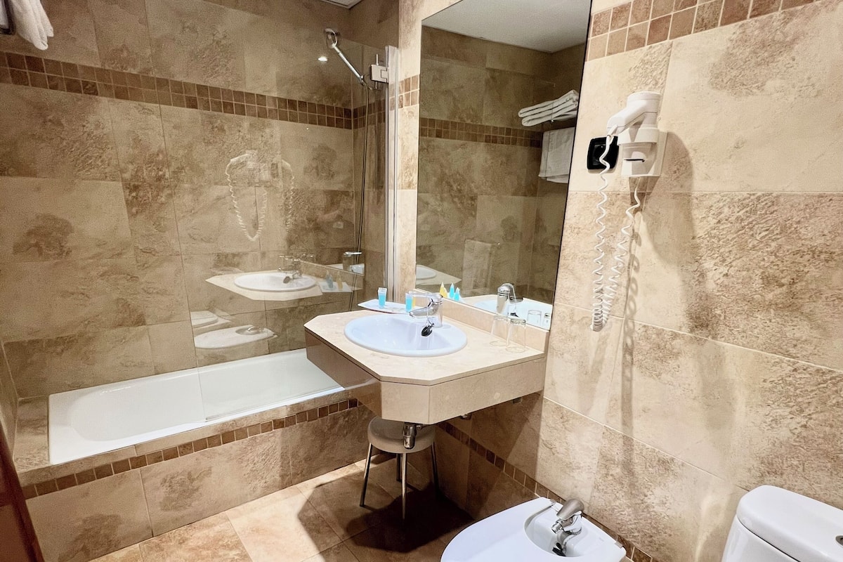 Une salle de bain équipée d’une baignoire, d’un lavabo, de toilettes et d’un bidet.
