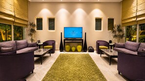A modern living room with a flat-screen TV, two sofas, a coffee table, and decorative vases. - Vivienda Hotel Villas, Turki Al Awwal (Riyadh)