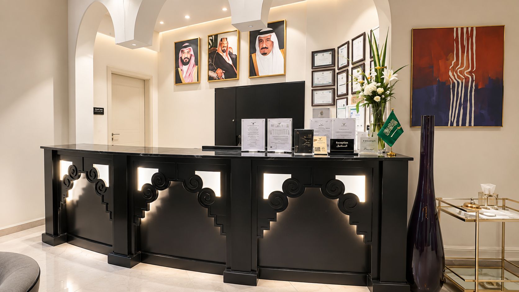 A reception desk with framed certificates, a reception sign, and a modern abstract painting.