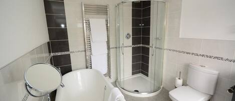 A bathroom with a bathtub, toilet, and shower stall.
