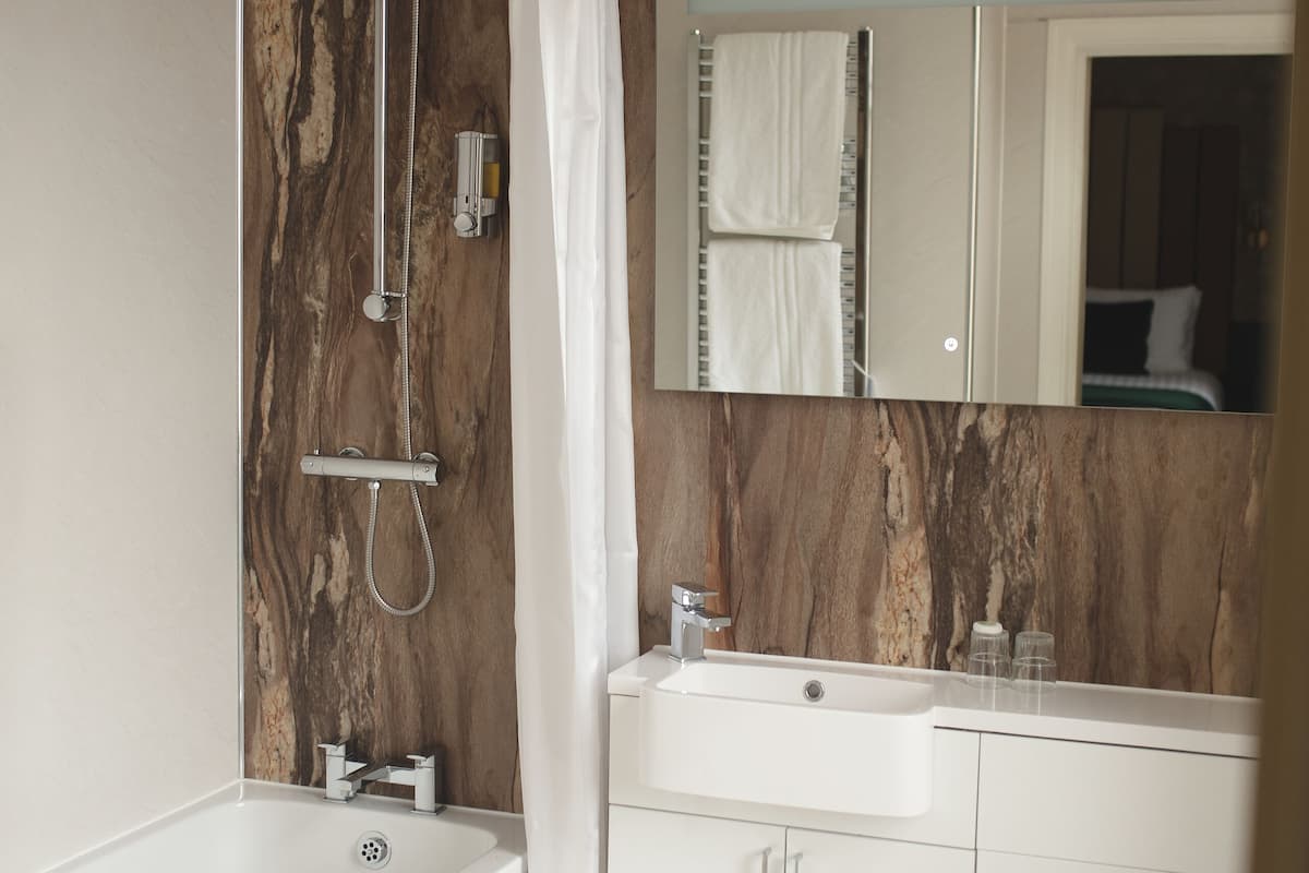 combined shower/bathtub, designer toiletries, hair dryer, towels