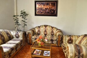 Habitación triple estándar | Área de sala de estar | Televisión de pantalla plana de 32 pulgadas con canales por cable