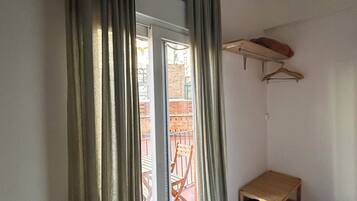 Ein Zimmer mit einer Schiebeglastür, einer kleinen Holzbank und einem Wandtrockner.