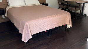A neatly arranged hotel room with a large bed, a desk, and a chair. - Cadet Motel (Cornwall)